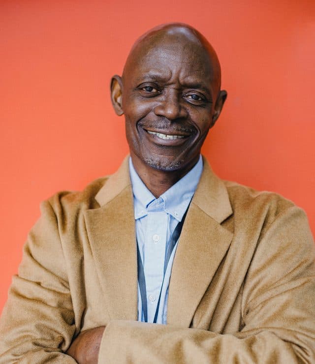 A business owner with arms folded, smiling